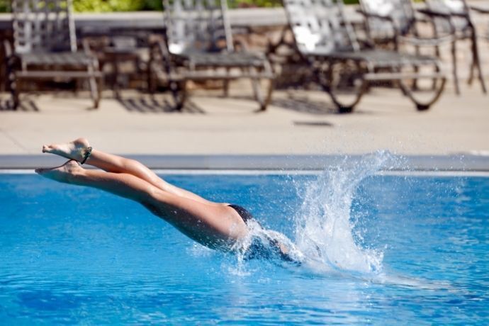 Mulher mergulhando em piscina de clube