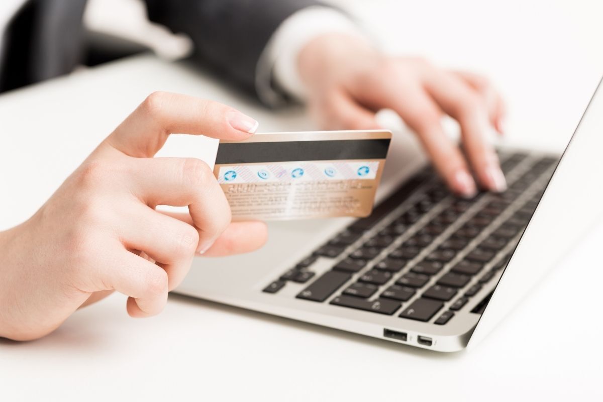 Homem fazendo compra na internet com cartão de crédito.