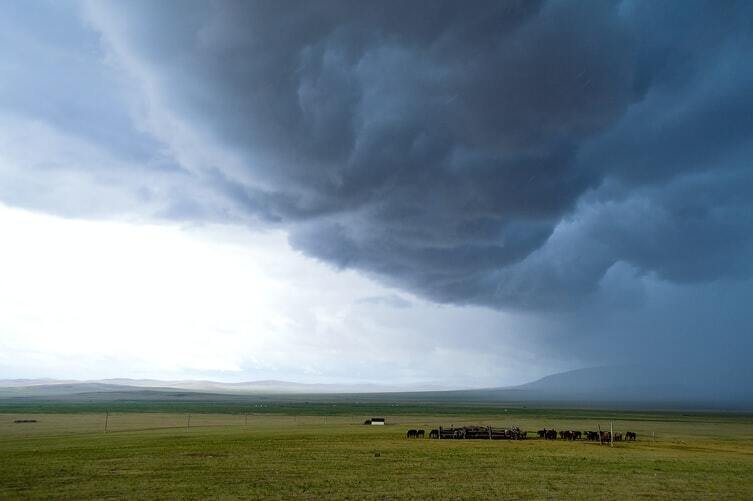 Campo aberto com nuvens escuras no céu