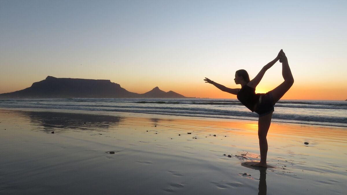 Mulher fazendo Yoga no mar.