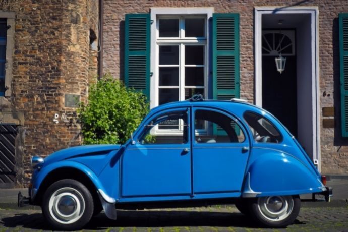 Fusca azul estacionado na frente de uma casa