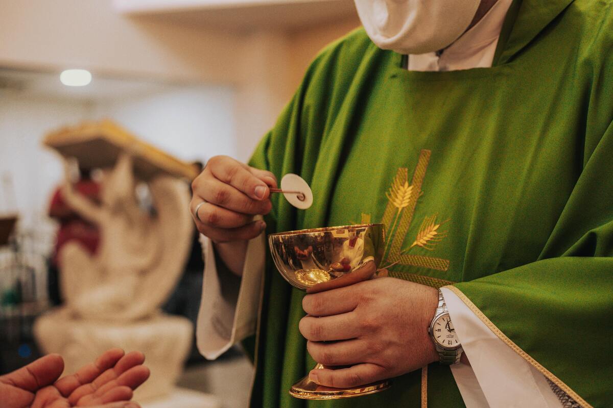 Padre com hóstia realizando missa