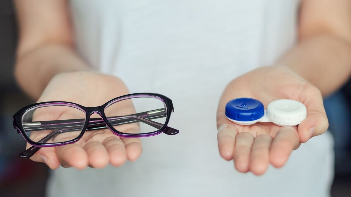 Mulher segurando óculos e lentes.