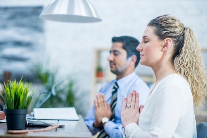 Homem e mulher rezando no trabalho