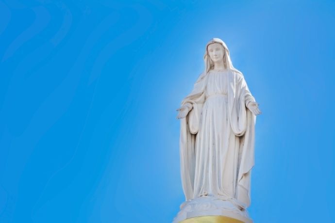 Estátua da Virgem Maria em frente ao céu azul