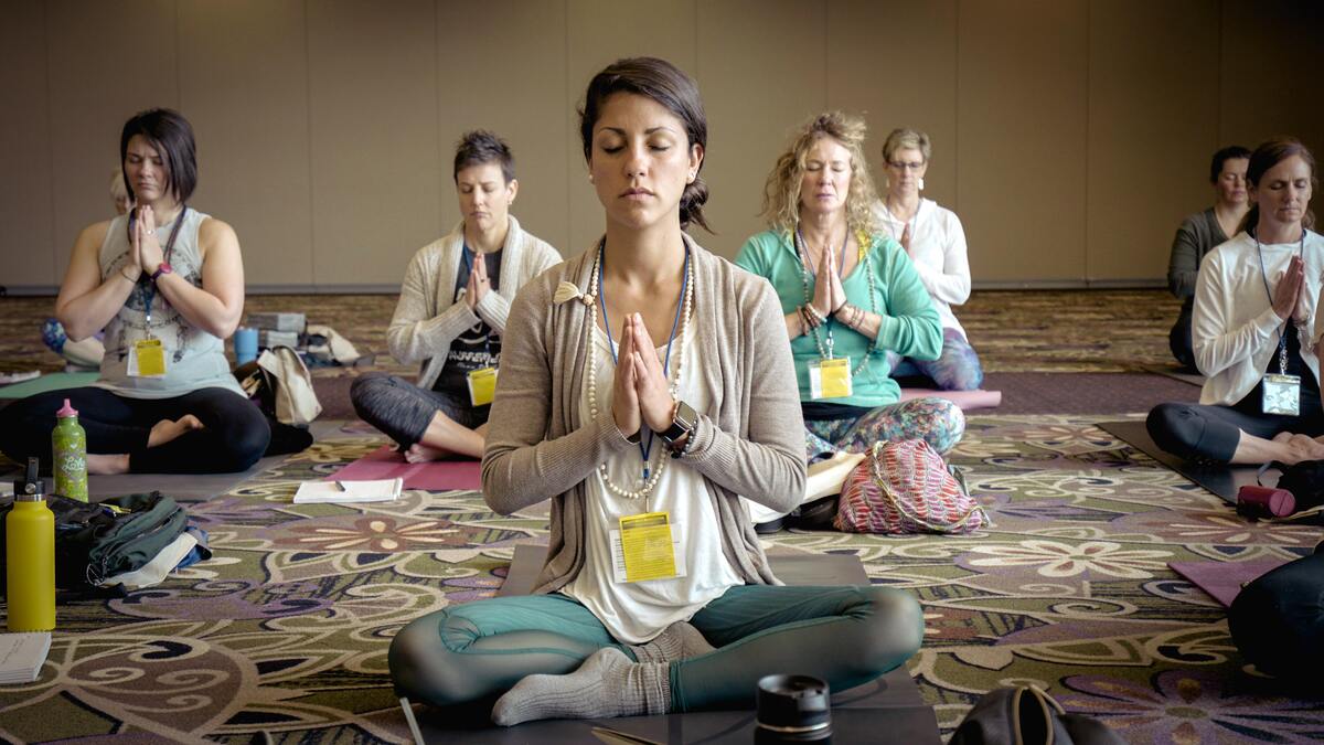 Pessoas fazendo Namastê na yoga.