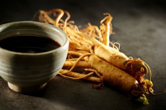 Ginseng ao lado de xícara