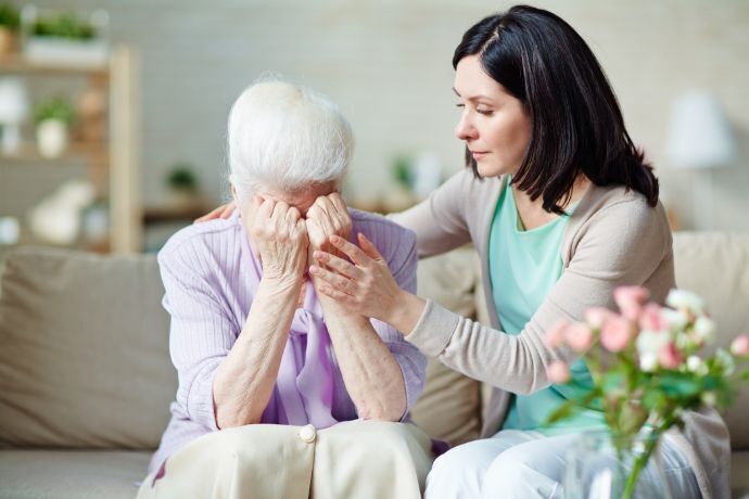 Senhora sendo consolada por mulher