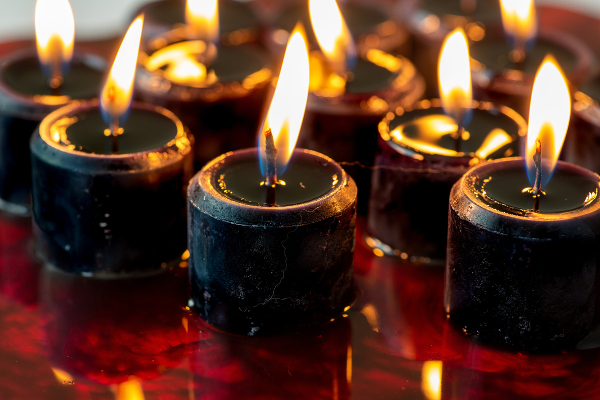 velas pretas acesas sobre líquido vermelho.