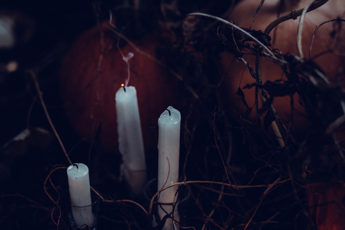 Três velas longas apagadas, com o rastro da fumaça ainda presente. 