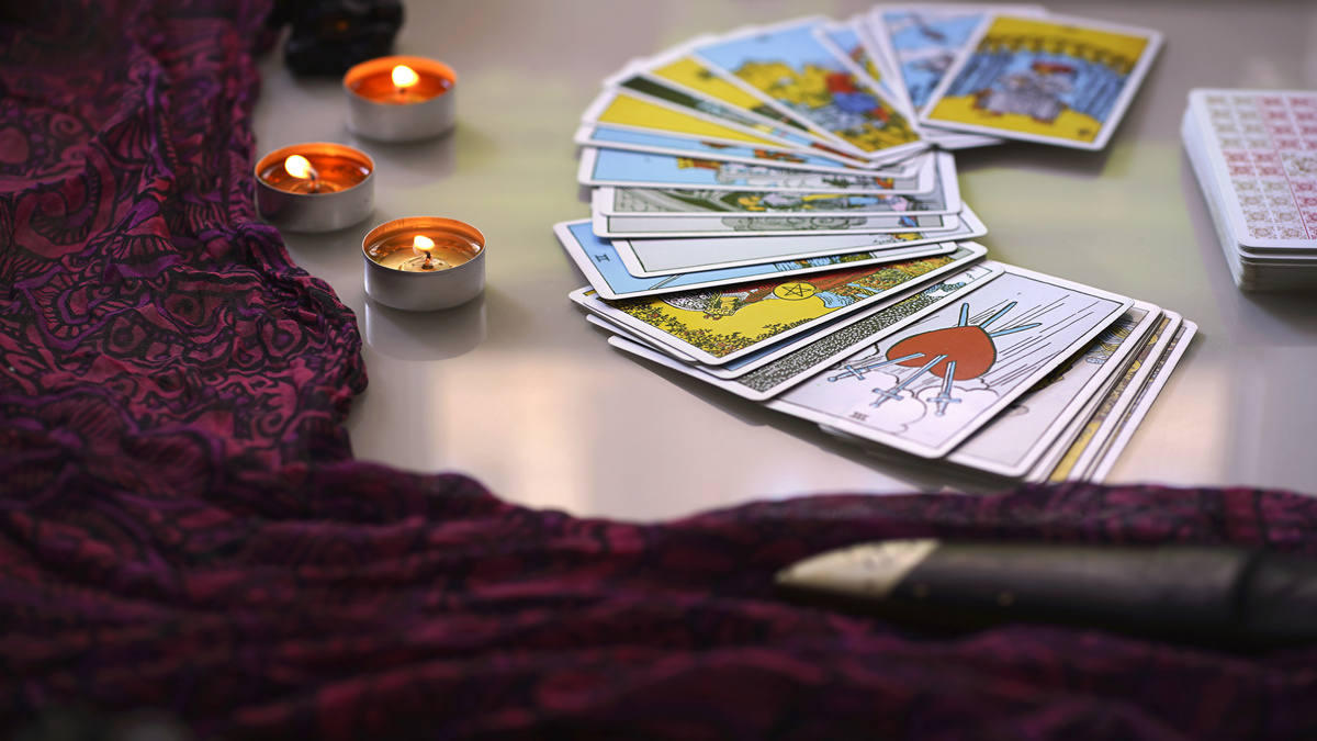 Cartas de Tarot, velas e um tecido.