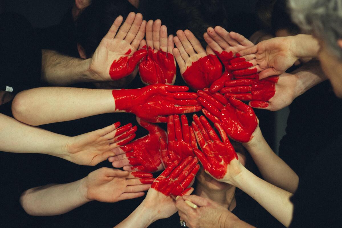 Várias mãos que, juntas, formam um coraçãoç. 