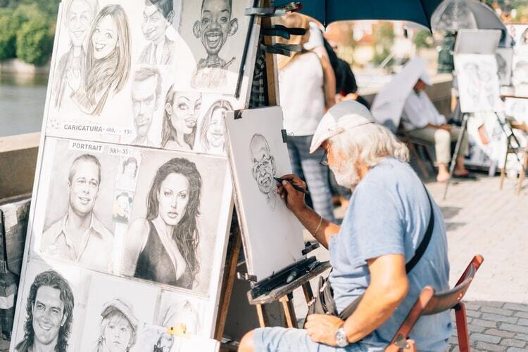 Homem sentado desenhando rostos