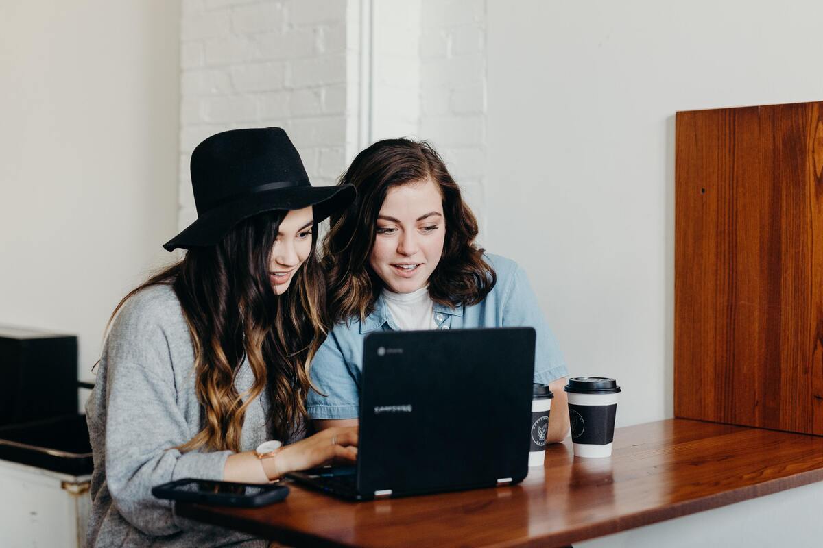 Duas mulheres em frente a um computador. 