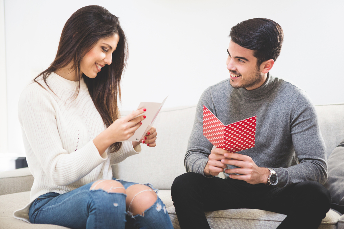 Mulher lendo pedido de namoro escrito por homem ao seu lado