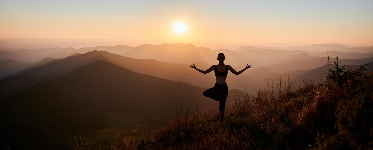 Mulher fazendo yoga na montanha.