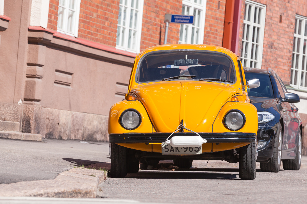 Fusca amarelo estacionado ao lado da calçada.