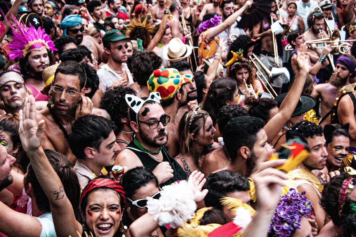 Pessoas fantasiadas em bloco de carnaval. 