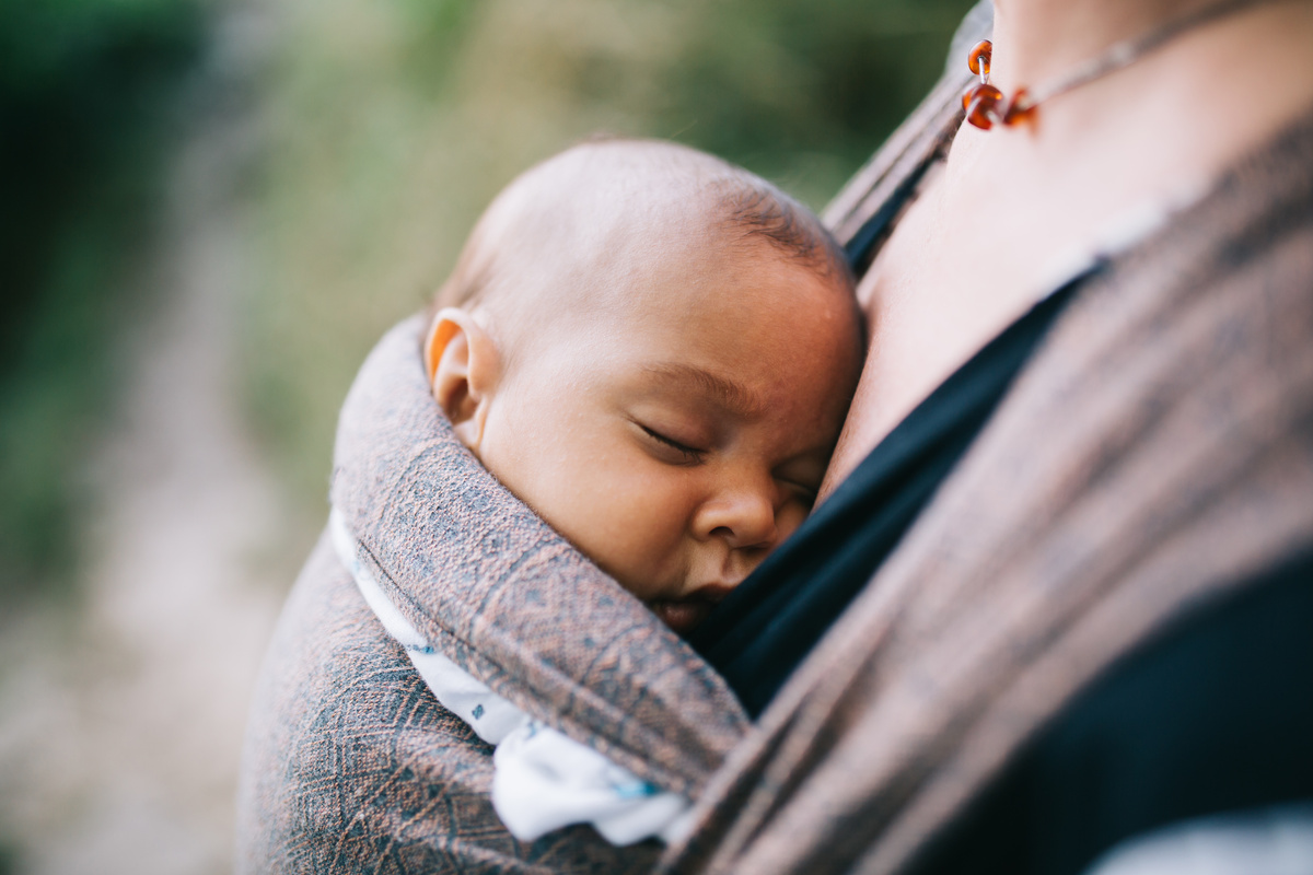 bebê adotado dormindo no colo de mãe adotiva.