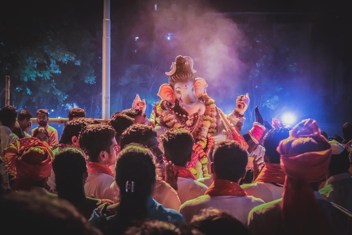 Fiéis hindus cultuando estátua de Ganesha. 