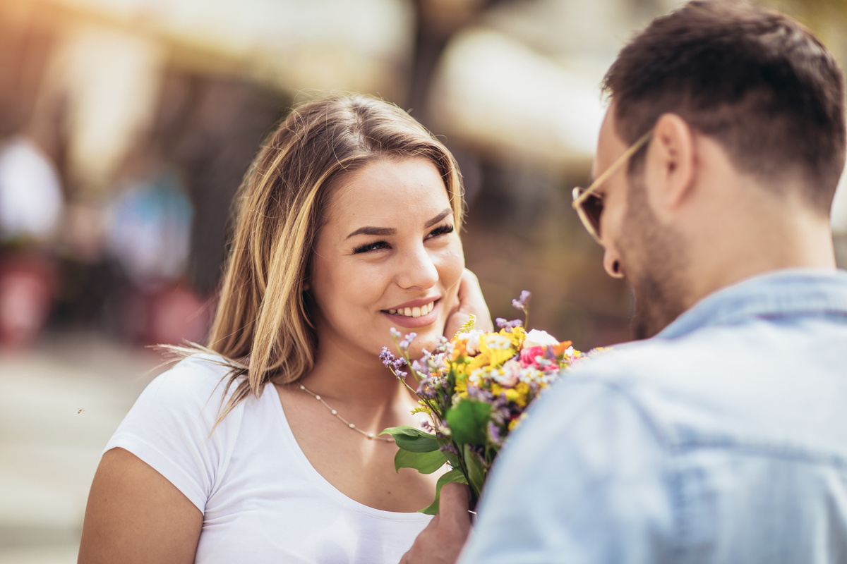 Homem dando buquê de flores para mulher