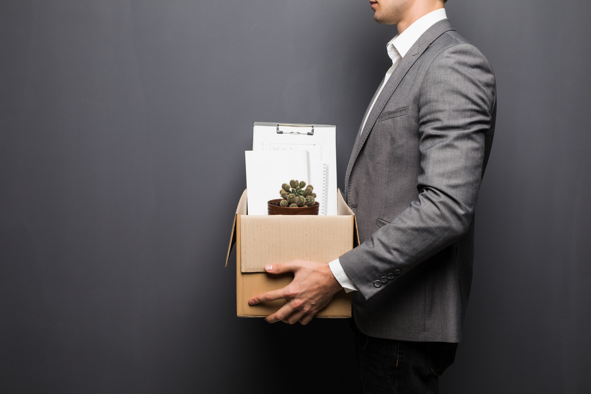 Homem que foi demitido do emprego carregando suas coisas