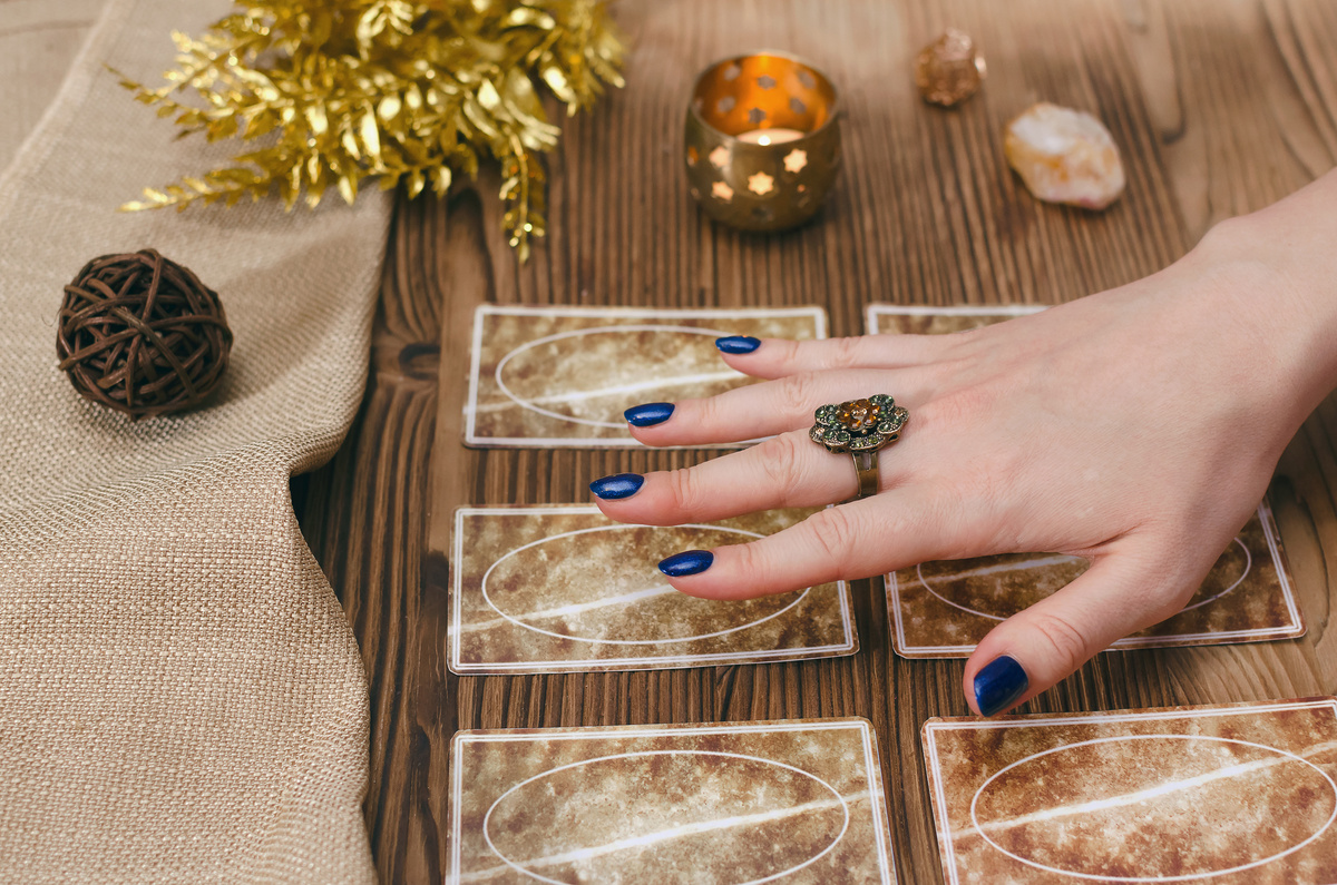 Mão feminina em cartas do Baralho Cigano