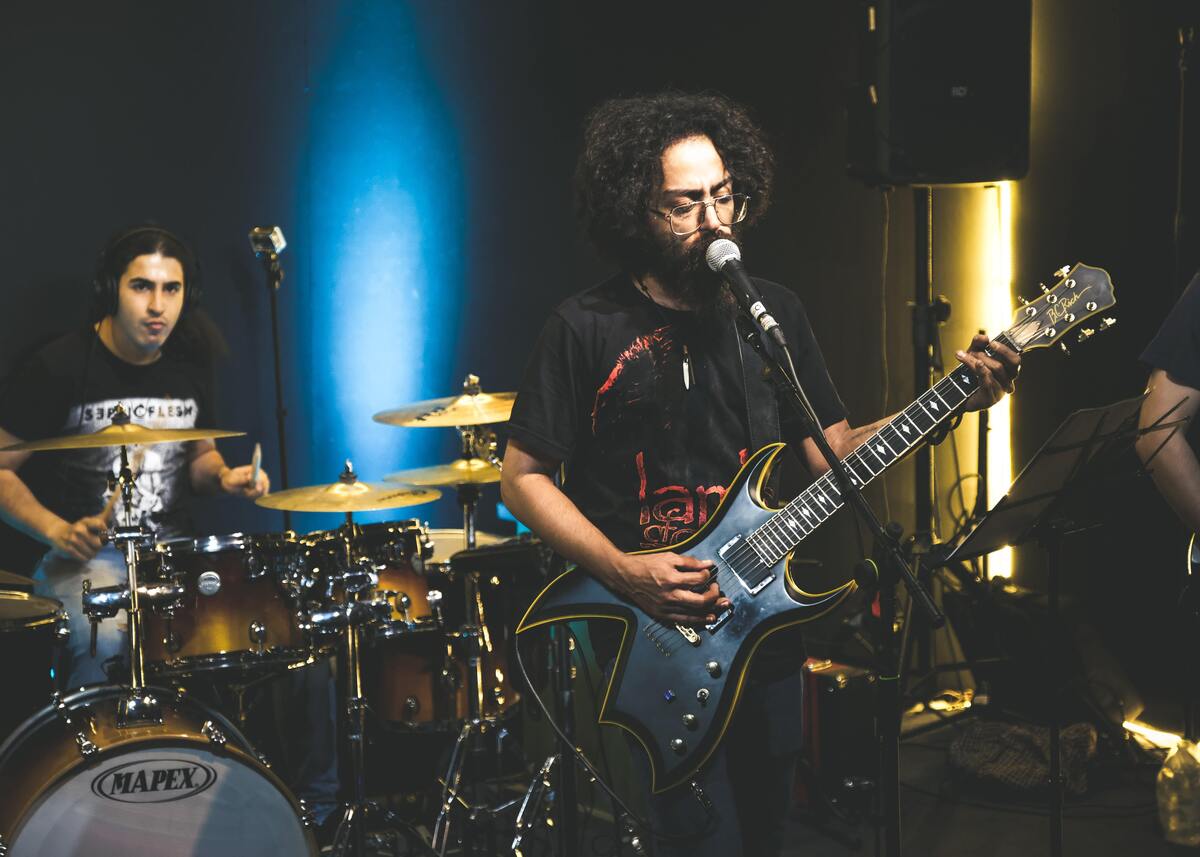 Cantor de banda cantando e tocando guitarra