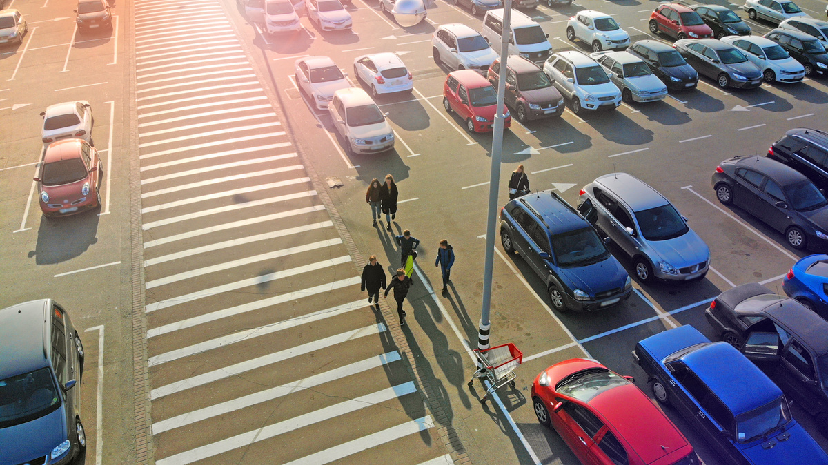 Estacionamento com pessoas e carros