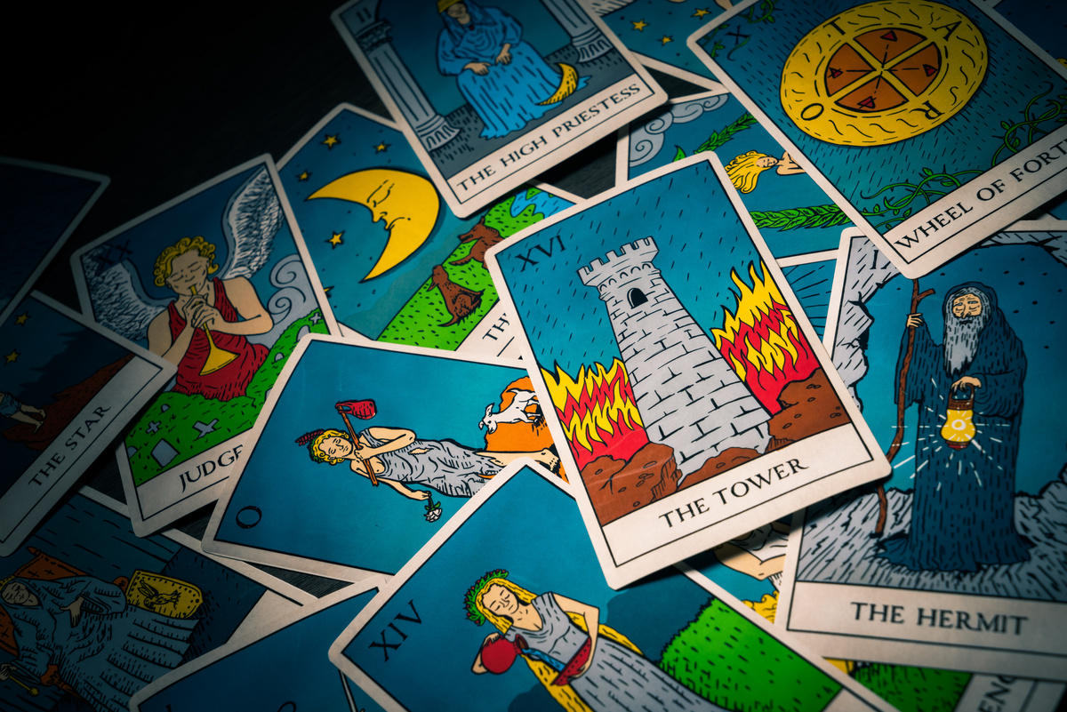 Carta A Torre em evidência enquanto em cima de várias outras cartas de baralho de tarot.