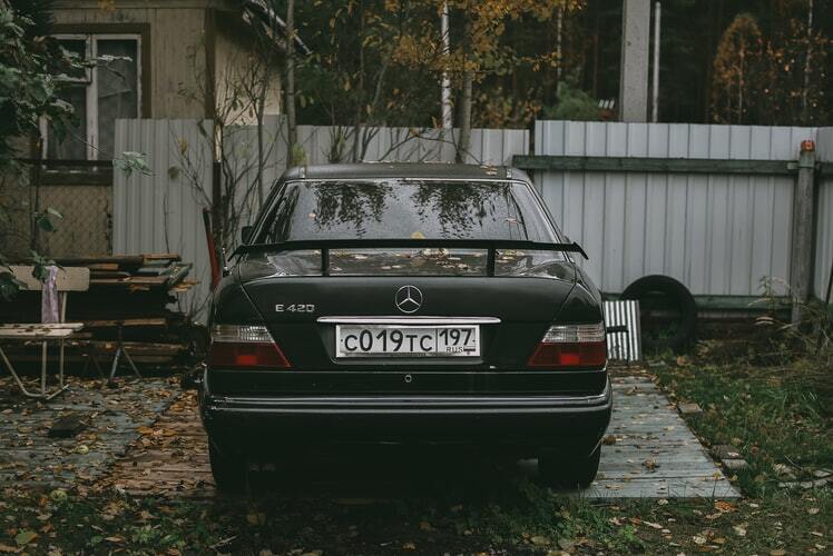 Carro preto estacionado em jardim