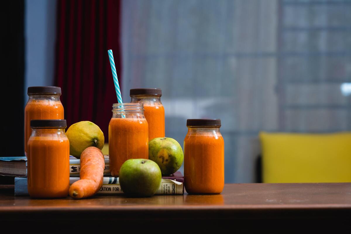 Jarras de vidro com suco de laranja e cenoura dentro.