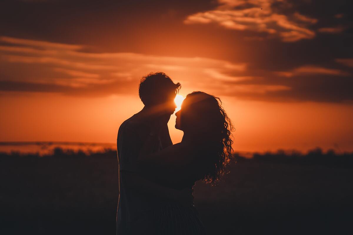 Silhueta de um casal em um campo aberto. 