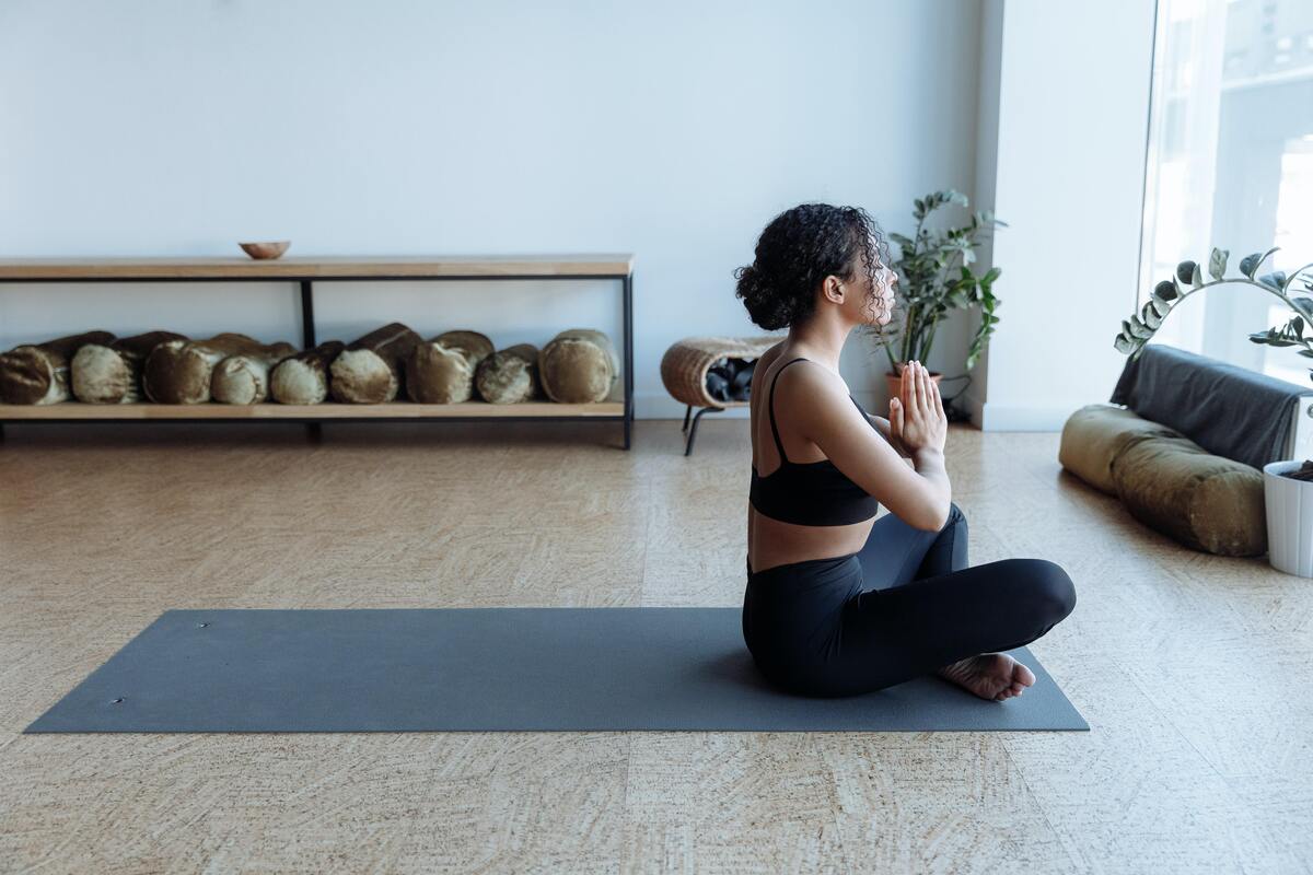 Mulher fazendo meditação em casa