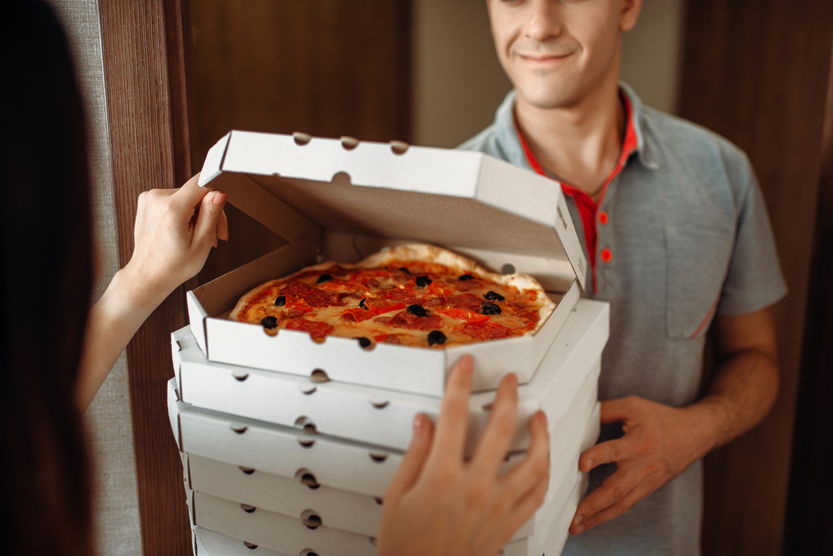 Entregador de pizza na porta de casa.