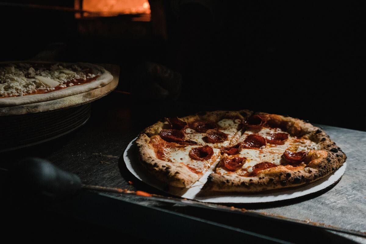 Pizza sendo cortada.