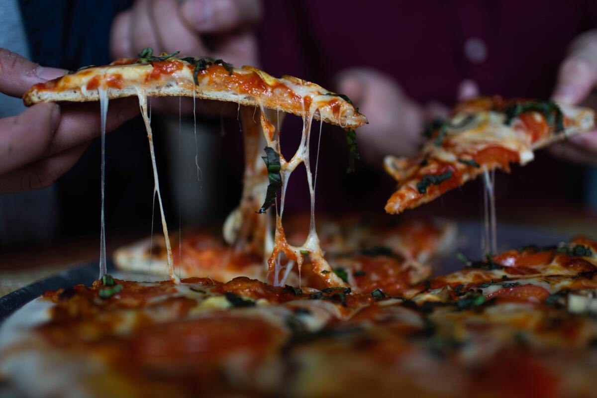 Pedaços de pizza sendo tirados.