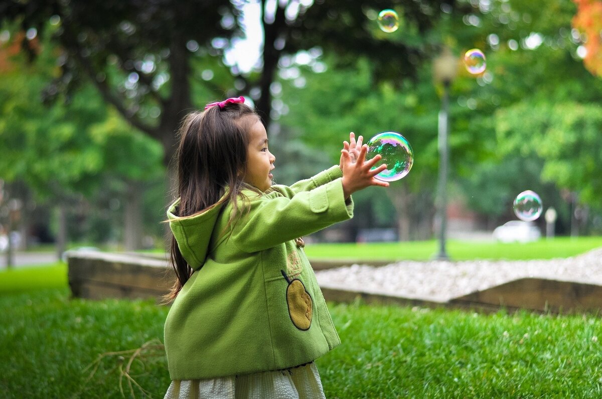 Menina brincando com bolhas de sabão.