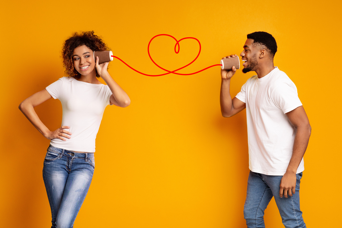 Casal conversando por telefone sem fio que forma um coração