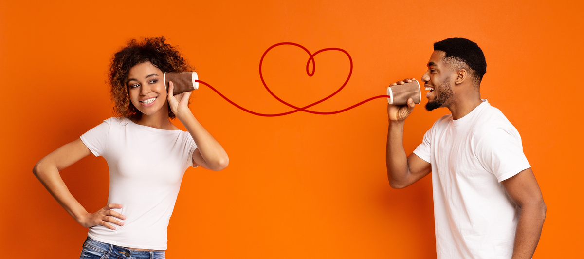 Homem e mulher com telefone sem fio que forma coração