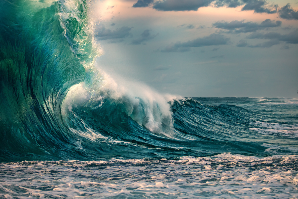 Ondas grandes e esverdeadas se formando no meio do mar. 