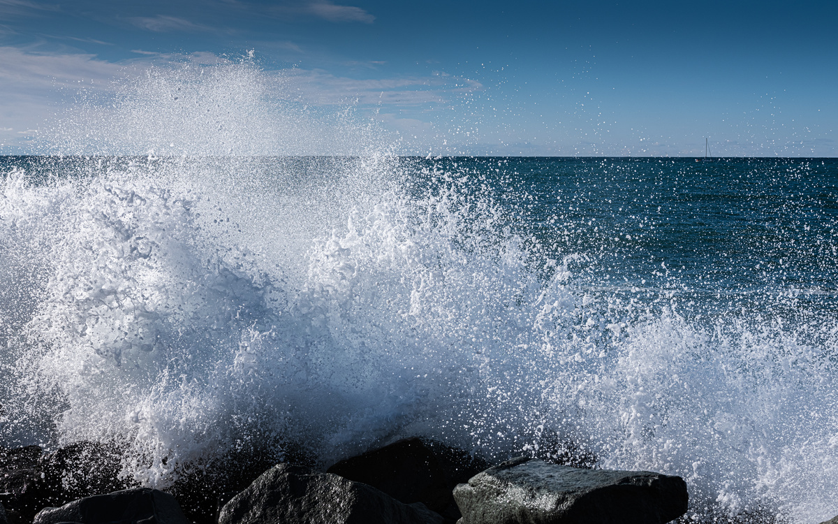 Ondas grandes se quebrando em rochas na beira da praia.