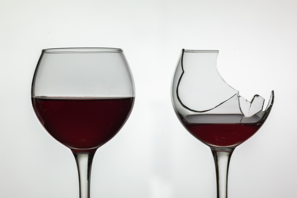 Duas taças de vinho tinto, uma está quebrada