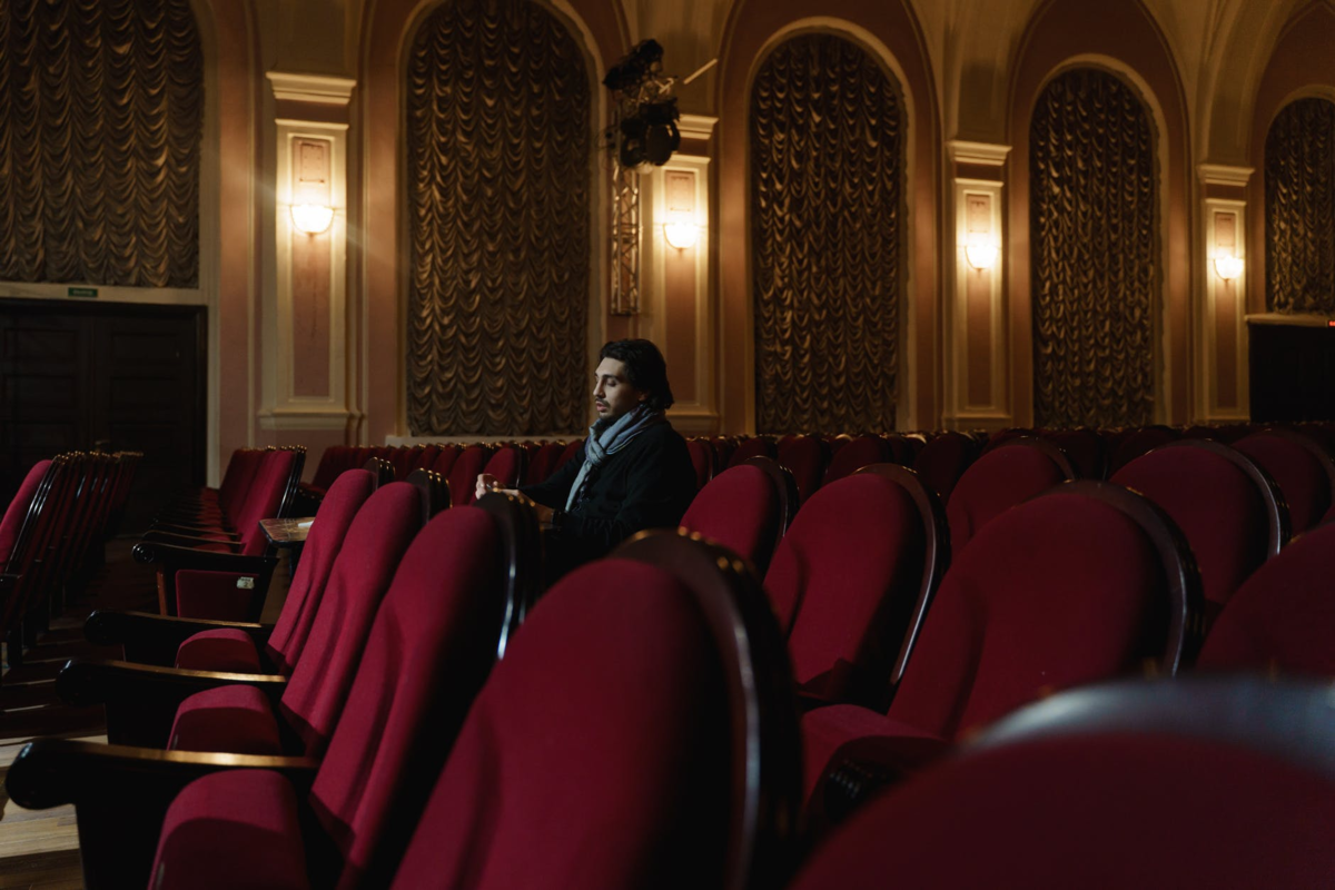 Homem assistindo à peça de teatro