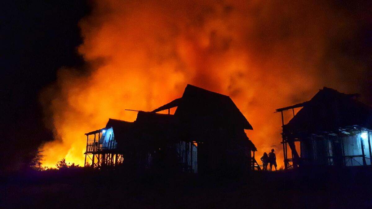 Silhueta de uma casa pegando fogo.