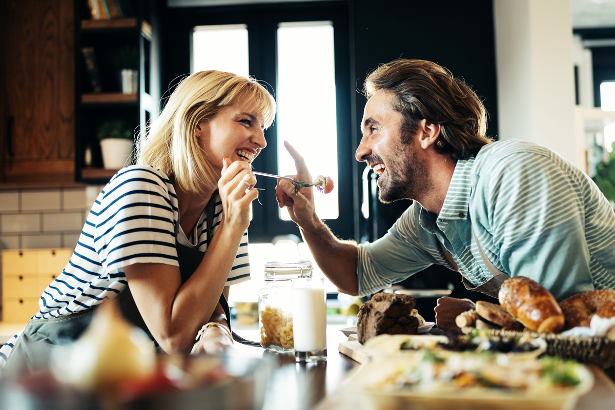 Casal de homem e mulher cozinhando juntos.