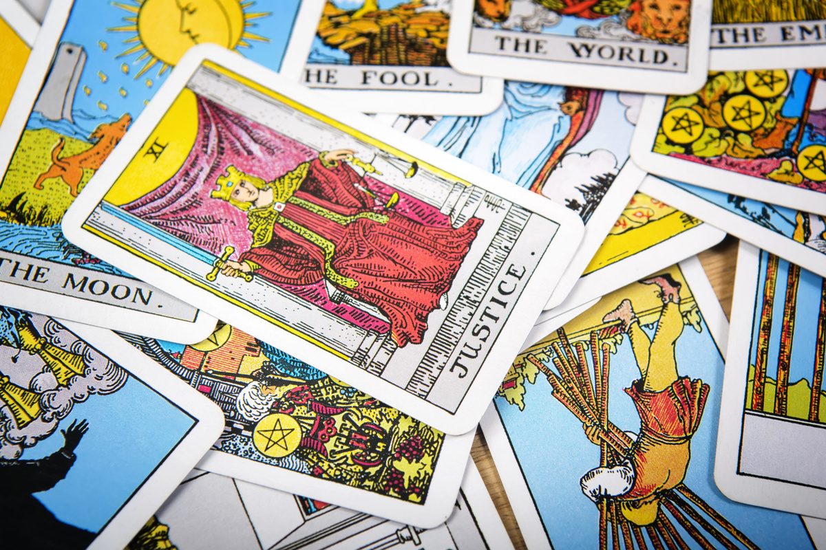 Carta A Justiça em cima de outras cartas de Tarot embaralhadas.