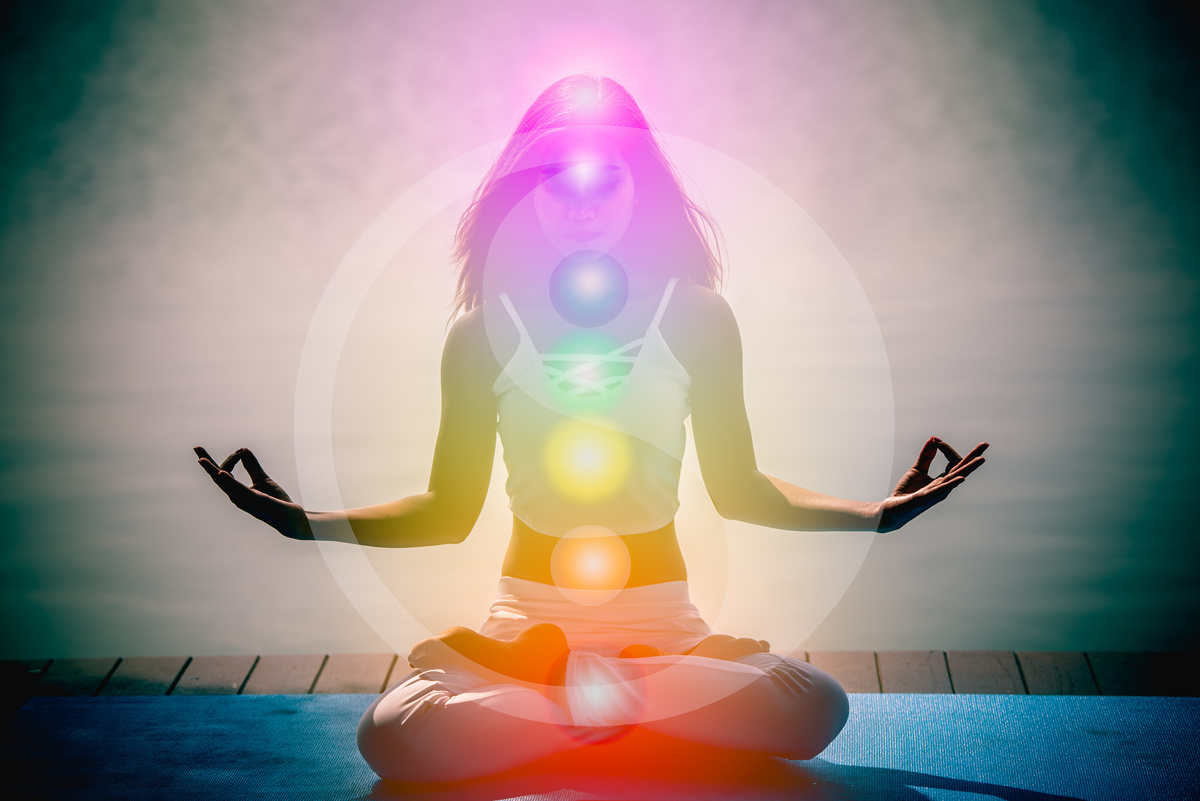 Pessoa meditando com os 7 chakras.