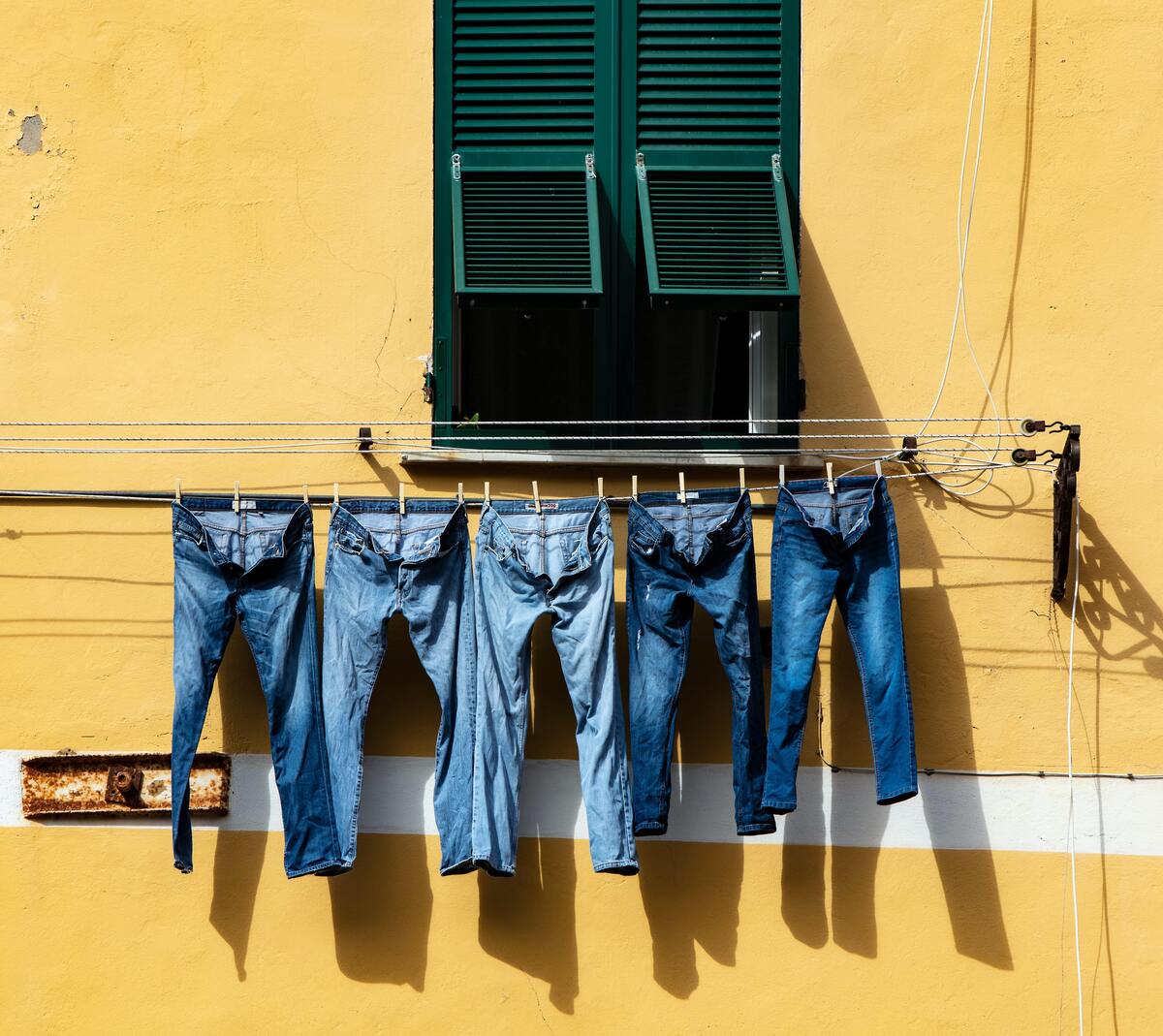 Calças jeans de diferentes tipos penduradas no varal.