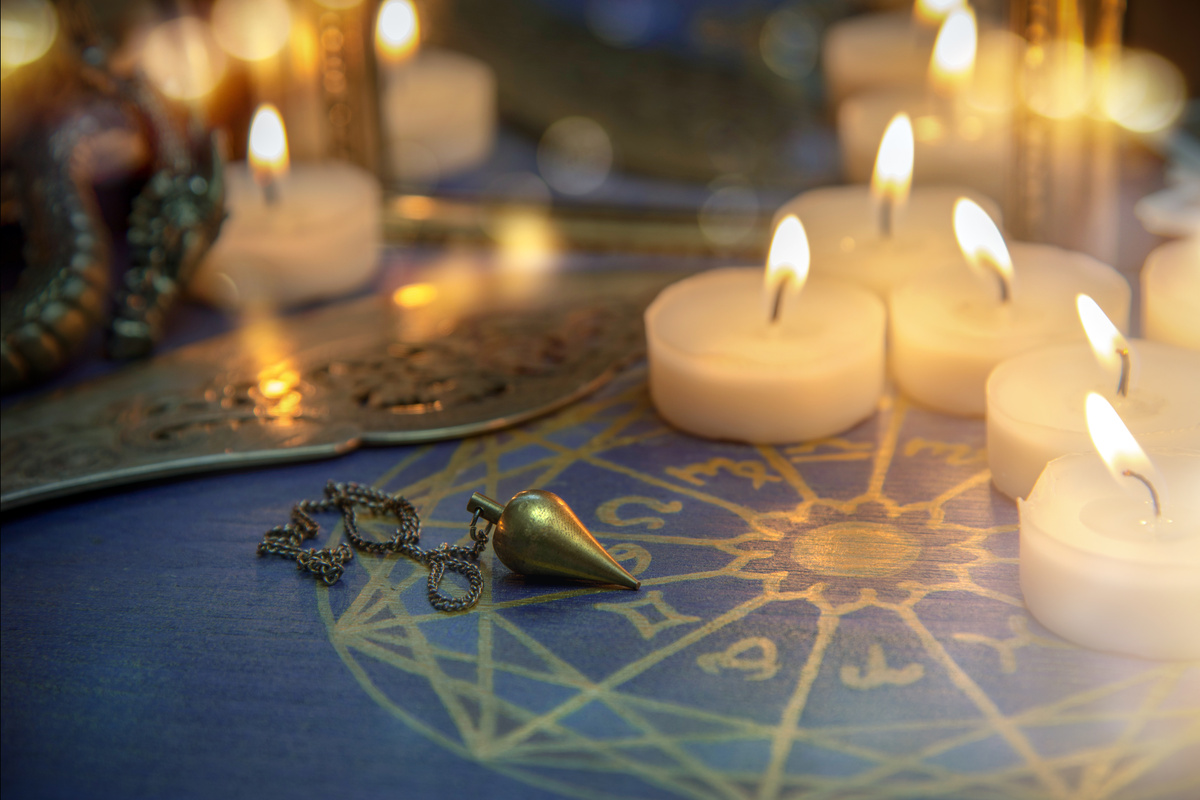 Altar com velas, mapa astral e bola de cristal.